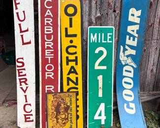 Painted signs that say full service, oil, change, carburetor, Mile 214 sign , blue Goodyear sign