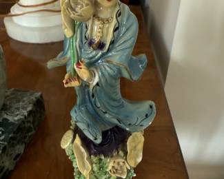 porcelain figurine of Kwan Yin, the Chinese goddess of compassion and mercy. Kwan Yin, also known as Guanyin, Quan'Am, Kannon, and Kanin, is a beloved figure in Asian culture, symbolizing compassion and loving-kindness