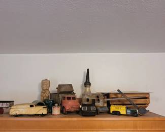 A collection of antique toys including a viewmaster, metal vehicles, an oil can and a Kahlua decanter.