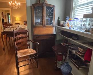 English secretary with leaded glass , antique clock, dining room arm chair , collectible items .
