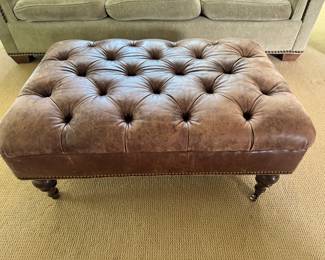 Tufted leather ottoman on casters