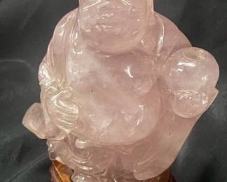 Pink quartz laughing Buddha on wood stand