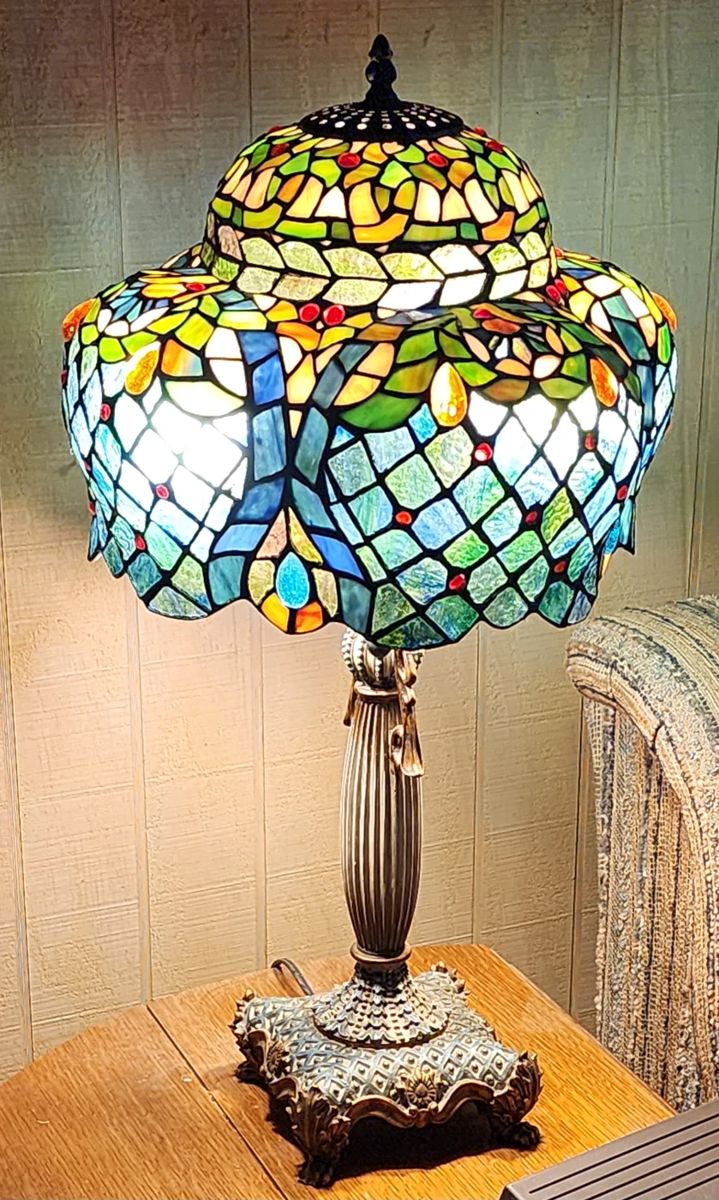 This is a stunning Tiffany-style stained glass table lamp with an elaborate multi-tiered shade. The lampshade features intricate leaded glass work in a complex pattern that combines several design elements.