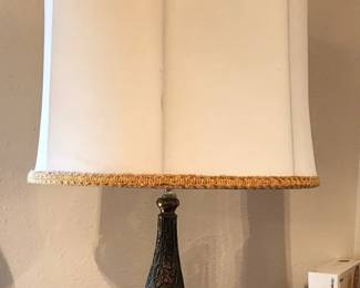 Hollywood Regency Jeweled Falkenstein Regal style table lamp, likely made by Carl Falkenstein. These lamps are known for their opalescent glass bases with hand-painted floral designs, often accented with gold. The lamp features a white shade with gold trim, adding to its glamorous aesthetic.
Falkenstein produced these lamps from the 1940s to the 1960s, and they are highly sought after by collectors for their unique design and vintage charm.