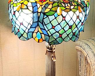 This is a stunning Tiffany-style stained glass table lamp with an elaborate multi-tiered shade. The lampshade features intricate leaded glass work in a complex pattern that combines several design elements.