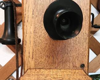 Antique Kellogg Switchboard and Supply Company wall phone. Oak wood construction with visible bell system at the top, a distinct transmitter, and a side-mounted receiver hook.
