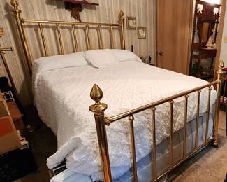Classic and elegant queen size brass bed. The bed features a headboard and footboard made of polished brass, with vertical rods and decorative finials at the top of each post. Includes mattress.