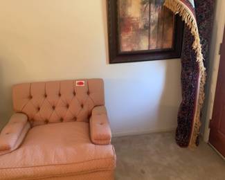 Overstuffed comfortable armchair, vintage rug, wall art