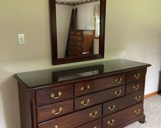 Cherry bedroom set includes one ten drawer dresser with mirror, two seven drawer tall boy chests, one nightstand and queen bedframe (four posters also available)