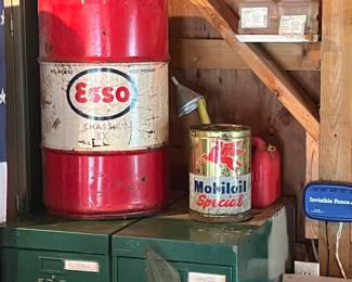 Vintage Esso and Mobil special grease cans on top of a multi drawer metal cabinet.
