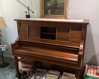 Player piano with Music rolls and vintage sheet music.