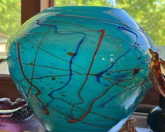 This stunning vintage Viz Art Glass vase is a beautiful addition to any home decor. The large, handblown centerpiece bowl features a mesmerizing abstract design in shades of turquoise and green. The glass material adds a touch of elegance and the retro style makes it a perfect gift for any occasion, whether it be a birthday, Christmas, or Mother's Day.
Crafted with the highest quality of handmade art glass, this vase is an original piece and boasts a production technique of hand blown glass. The vase stands at 10" tall and 12"wide, making it a statement piece in any room. This vase is perfect for displaying flowers or as a standalone piece.