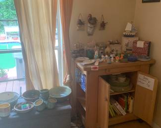 Rolling kitchen cart with salt and pepper, shakers and other interesting collectibles, southwestern style dish, set on top shelf, and cookbooks on the bottom of