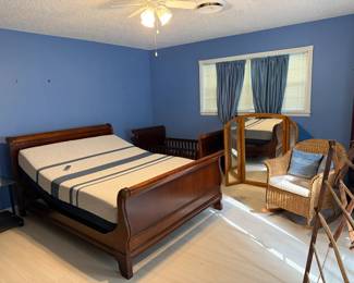 Bedroom items. Adjustable queen bed with wood sleigh-style frame. Sleigh-style baby crib/bed - Makes a great large dog bed. Quilt rack. 3-part mirror. Wicker rocker.