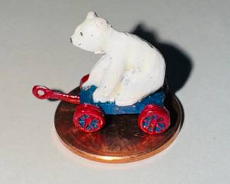 Metal miniature, polar bear riding a wagon