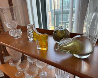 Large Clear Pedestal Vase Eastern European or American crystal.
Clear Crystal Animals Nachtmann (Germany),
Amber & Clear Glass Kosta Boda
Glass Apple & Pear with Gold Infusion Murano
Tall Abstract Sculpture (Far Right) Orrefors / Steuben-style.
Lower Shelf: Coupe Glasses 1950s–70s. Fostoria, Cambridge, or Heisey.