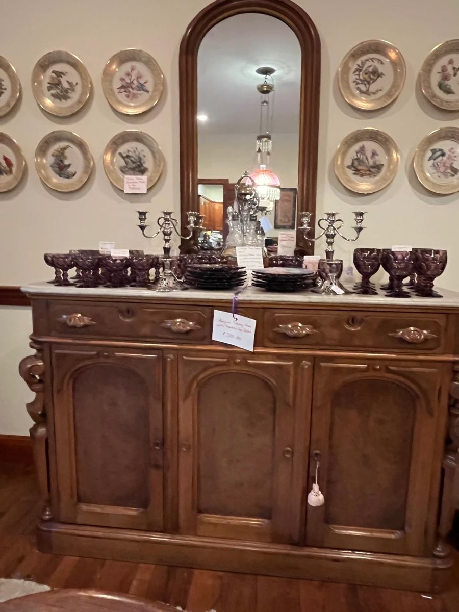 Lenox china on wall, Antique buffet and mirror, and plum dishes.