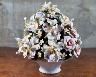 This lot features a large floral arrangement center piece, manufactured by Capodimonte. This arrangement measures, 13” H x 12” W x 12” D. Capodimonte porcelain, soft-paste porcelain produced by a factory established in 1743 at the Palazzo of Capodimonte by Charles III of Naples. Ware was produced there in large quantity and wide variety until 1759, when the concern was dismantled and removed to Buen Retiro, near Madrid, when Charles became king of Spain. This item appears to be in very good condition. No in-house shipping available.