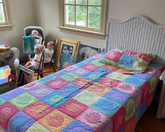 One of two wicker twin beds, antique and vintage toys in the background