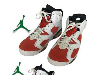 Two views of a single pair of cool Air Jordan Retro 6 athletic shoes in classic carmine;  laces fixed with a seal, indicating shoes never worn; size 12.  From Nike’s website:  “Inspired by MJ’s [Michael Jordan’s] German sports car, the Air Jordan 6 evoked an essence of speed and class.”