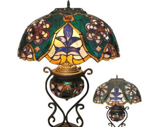 Large, impressive vintage Tiffany-inspired fleur-de-lis and floral design lamp, shown lit and unlit; two lights under shade and third light for oval luminous base; lamp w/shade 26”H; shade 19”W; from estate of avid lamp collector