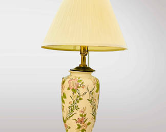 Vintage ceramic table lamp with a floral design. The lamp appears to be a vintage or antique ceramic table lamp, likely dating to the mid-20th century. The floral design on the ceramic base suggests a style that was popular in home decor during that time. Ceramic lamps were often produced with hand-painted designs, making each piece unique