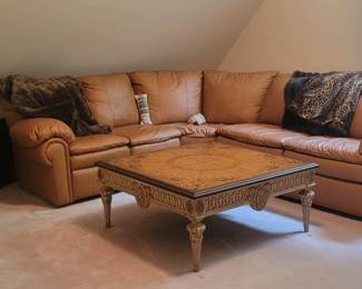 TVs, leather sectional with recliner and queen bed, coffee table. throws