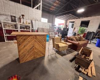 bamboo bar table, antique easle, tuffed antique chair, leather couch