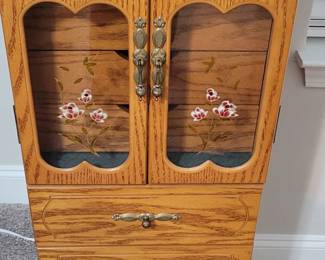 Freestanding jewelry box (6 drawers) with glass front and magnetic close.