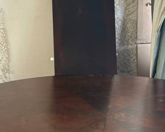Round Dining Table that includes a center leaf to create an oval.