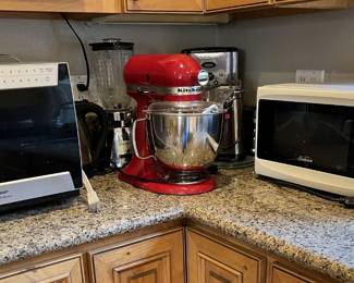 Back in the kitchen is a red Kitche Aide mixer and two microwaves, plus more.