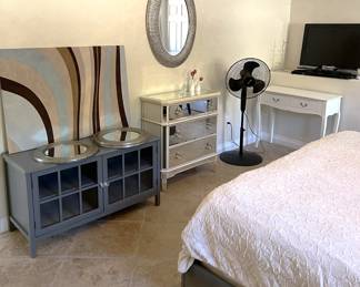 In this corner we have a pair of mirrors, the gray cabinet, a three-drawer dresser, stand fan, and makeup table.