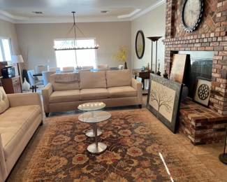 This overview picture of the living room shows several pieces, including the sofas and glass tables.