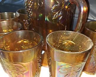 Carnival glass pitcher with cups
