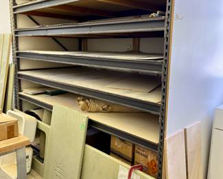 Large woodworking shop with lots of shelving, wood, tools, and equipment.