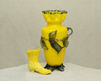 Antique Stevens & Williams art glass vase, opaque yellow glass with applied clear green rigaree glass leaves and blossoms, ruffled rim and tabbed feet, the body with uranium glass that glows under black light. Also shown a Fenton EAPG canary yellow milk glass Daisy & Button design ladies' shoe or boot, uranium glass.