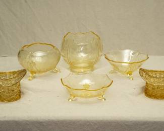 A pair of vintage Fenton amber glass Top Hat toothpick holders or trinket glasses, Starburst pattern; an antique Lancaster Glass Company Landrum Topaz three-footed rose bowl, a larger antique Lancaster Glass Company Landrum Topaz rose bowl, a Lancaster Glass Landrum Topaz #LAC36 three-footed bowl, and a Lancaster Glass Phoenix-Topaz three-toed bowl.
