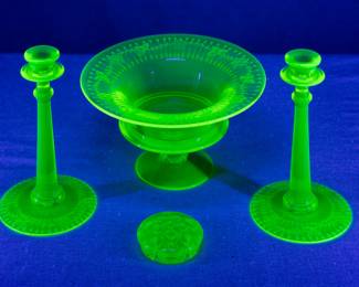 Seen under blacklight: An elegant set of vintage yellow/topaz vaseline glass compote and matching pair of candlestick holders, etched with a trellis and flowers pattern, possibly by Fostoria or Cambridge Glass; and a yellow uranium glass flower frog