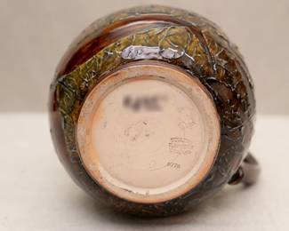 View of the base of the Royal Doulton Lambeth stoneware pottery jug with a leaf pattern in a brown and greenish glaze, circa 1891-1934