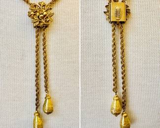 Another look at the vintage signed Miriam Haskell gold tone lariat / slide chain necklace, the slide a dimensional floral spray and the chains ending with a tear-shaped textured bead