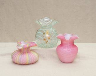 A vintage rainbow satin quilted MOP cased art glass vase with tri-curled rim, a Nailsea style pulled feather or drapery pattern pale green art glass vase with hand painted gilt floral decoration, and a pink and white cased glass vase with ruffled rim, either MOP or a Peloton style design application
