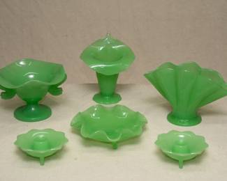 American art glass: A collection of vintage Fenton Art Glass in Jadeite green including a pair of lotus petal form candle holders, a fan vase with scalloped edges, a ruffled edge three-footed low candy dish, a Jack in the Pulpit form vase, and a Fenton Jadeite glass dolphin or koi double handle pedestal bowl/compote.