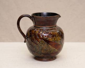 Another view of the Royal Doulton Lambeth stoneware pottery jug with a leaf pattern in a brown and greenish glaze, circa 1891-1934