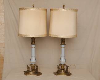 Pair of vintage table lamps with brass bases decorated with three griffins; pale gold fabric shades