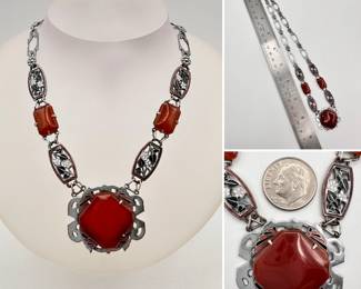 Vintage Art Deco necklace, silver tone with large red carnelian central pendant accented with red and black enamel, suspended by linked smaller carnelian cabochons and panels of black and white enameled flowers in red enameled frames
