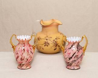 An exceptional pair of 19th century antique art glass vases, skillfully crafted with cased glass layers: An opaque white interior layer, a layer of crushed frit glass of pink, cream and brown, making a Vasa Murrhina streaked/patterned effect, topped with a layer of clear Aventurine glass containing diagonal swirls of reflective mica flecks. Finished with two applied amber glass thorn handles, and crimped rims. Also shown a Jugendstil/Aesthetic Movement subtly colored Burmese glass pitcher, hand painted floral decoration and applied frosted glass handle.