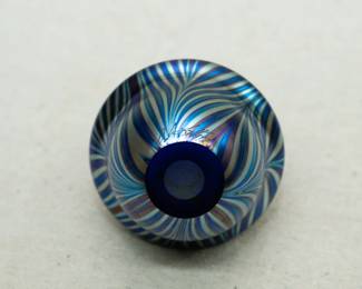 Closeup of a Charles Lotton art glass vase, pulled feather design over a rich dark blue, iridescent glass, signed
