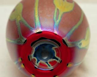 Closeup of a glowing iridescent red and gold art glass vase by Charles Lotton (1935-2021), signed and dated 1992
