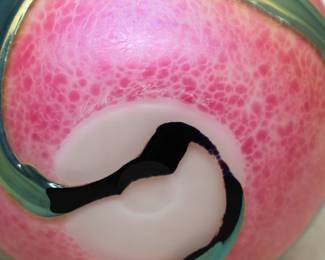 Closeup of the Charles Lotton studio 'Lava Cypriot' art glass vase. Signed and dated "1988". Iridescent green gather over pink marbled textured ground. Pinched rim.