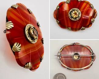 Late 19th century Scottish pebble jewelry brooch, sterling silver frame with a oval red agate carved in a Celtic shield shape, with carved lines radiating from a central boss sporting a faceted citrine. The agate held with shell shapes curving up from the frame. Unmarked